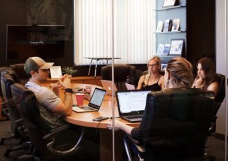 workers sitting around a conference room table working on computers