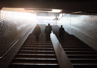 business people walking up an ominous staircase