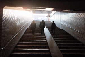 Business people walking up a dark ominous staircase