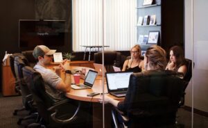 workers sitting around a conference room table working on computers